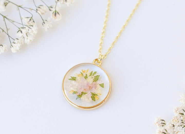 A custom gold resin necklace with flowers. Flowers are from a wedding bouquet, funeral, anniversary, graduation. Handmade pressed flower preservation jewelry gift.