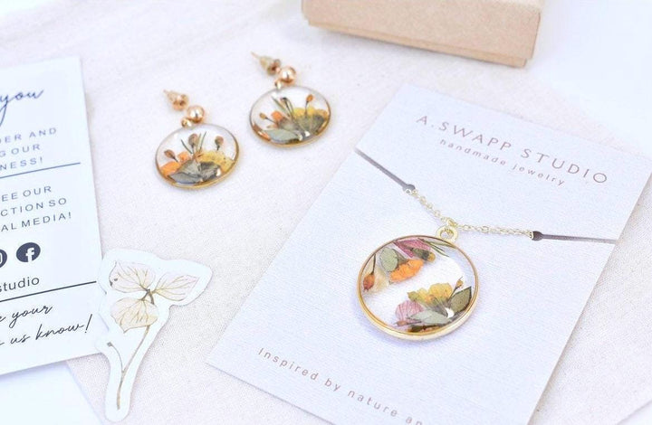 A custom gold resin necklace with flowers. Flowers are from a wedding bouquet, funeral, anniversary, graduation. Handmade pressed flower preservation jewelry gift.