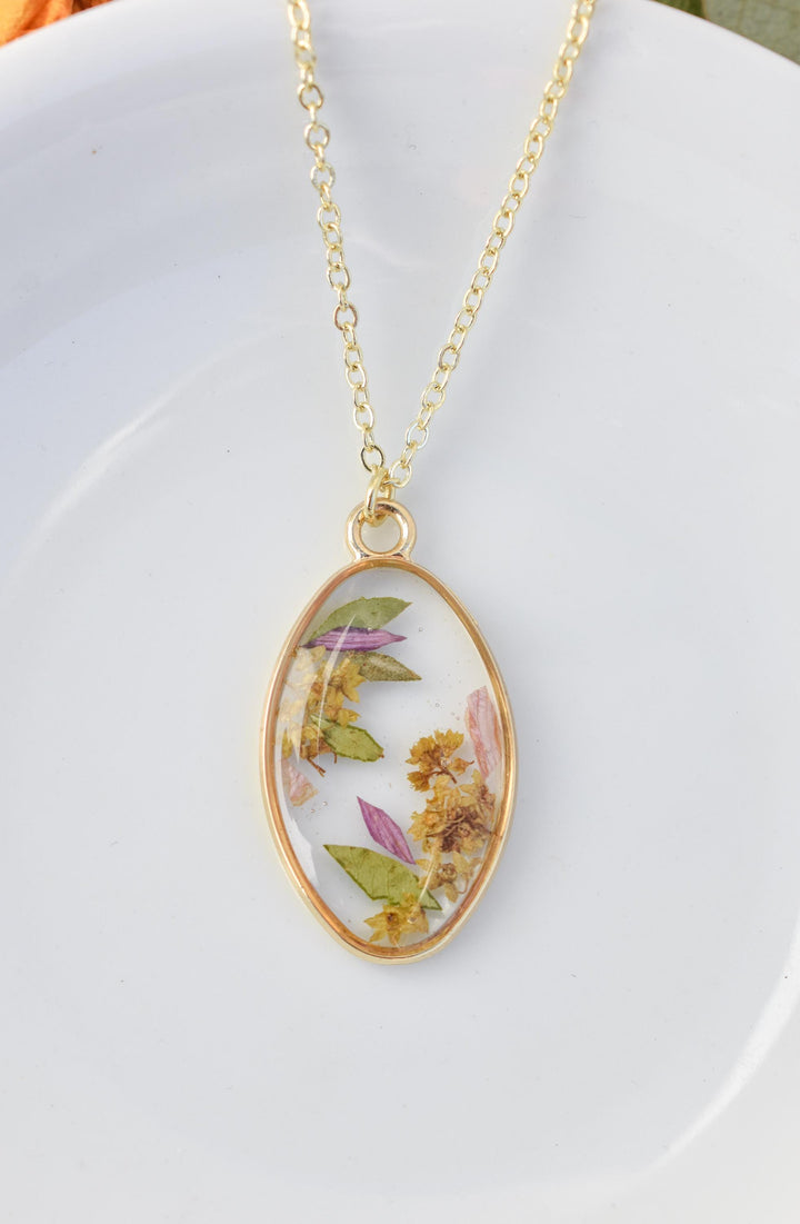 A custom gold resin necklace with flowers. Flowers are from a wedding bouquet, funeral, anniversary, graduation. Handmade pressed flower preservation jewelry gift.